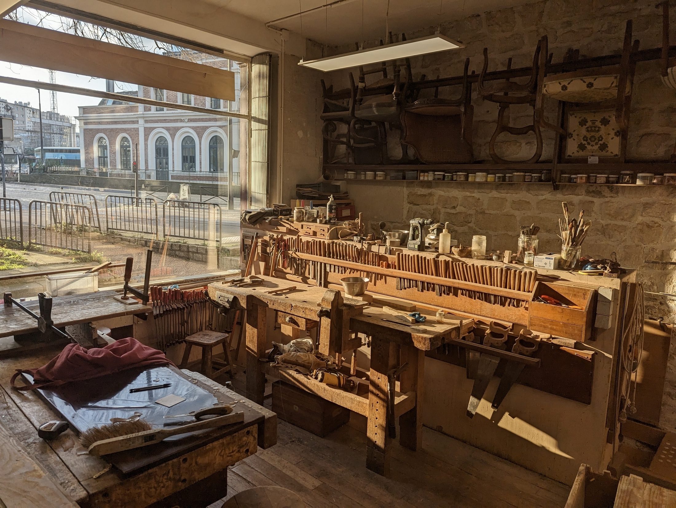 Établi et outils de l'atelier Hier et Demain, baigné de lumière
